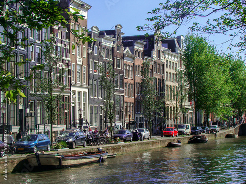 Obraz na płótnie Canal in Amsterdan (Netherlands) a bridge and people in which we can see the arquitecture of amsterdam's house. w salonie