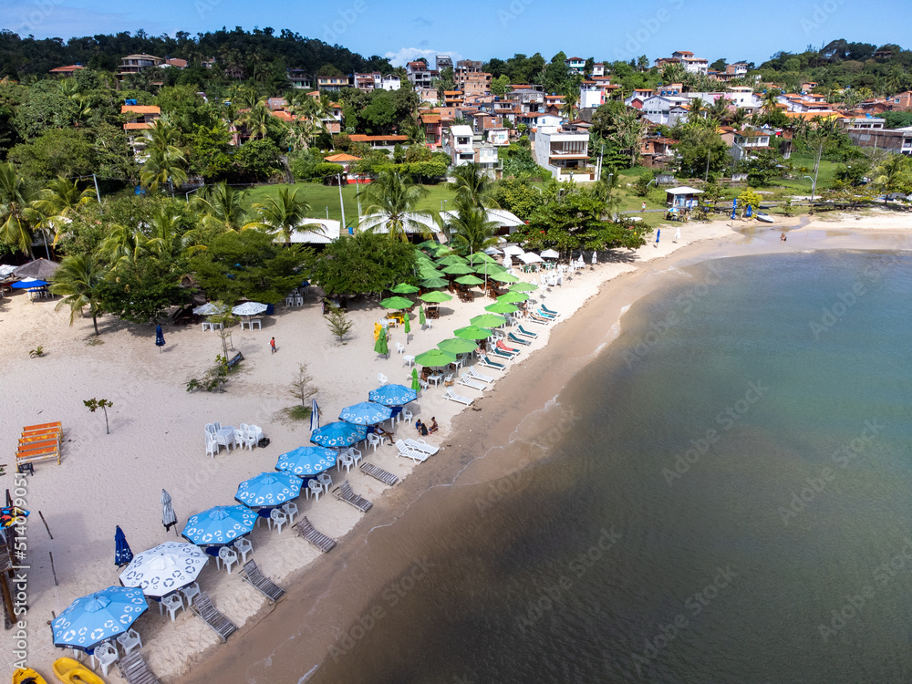 Beautiful and peaceful beach with dark waters and colorful beach sunshade - Gamboa, Bahia, Brazil