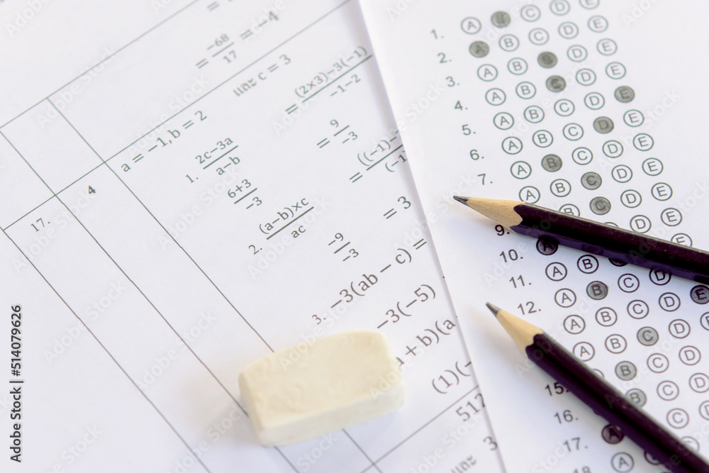Pencil and eraser on answer sheets or Standardized test form with answers bubbled. multiple choice answer sheet Pencil and eraser on answer sheets or Standardized test form with answers bubbled. multiple choice answer sheet