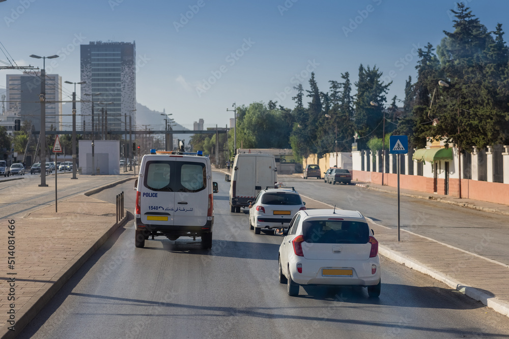Motorway in algeria, around the city of Oran. View of cars in african city traveling on multi lane highway..  Police car in front