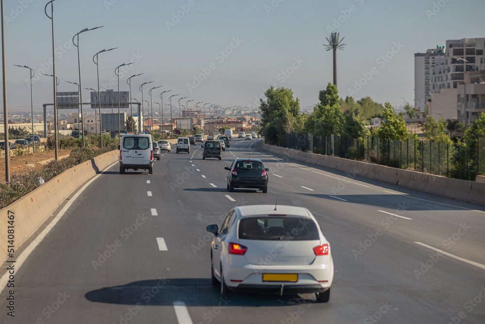Motorway in algeria, around the city of Oran. View of cars in african city traveling on multi lane highway..  Police car in front