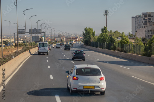Motorway in algeria, around the city of Oran. View of cars in african city traveling on multi lane highway..  Police car in front © Anze