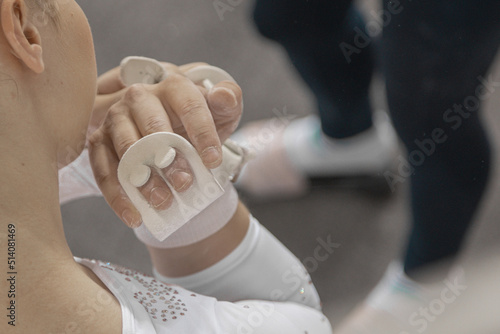 Hand grips or protectors for gymnast or gymnastic competition. White protective addons for fingers or palms used for competing in gymnastics. photo