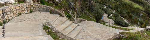 HUANCAVELICA, PERU - JUNE 29, 2022: Long path of cement steps that leads to the chapel of the Oropeza mountain. Road with many curves and a stone fence.