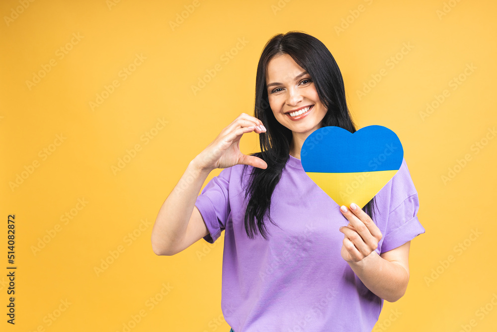 Portrait of nice beautiful lovely glad cheerful woman holding in hands Ukrainian flag having fun isolated over yellow pastel color background. Portrait of nice beautiful lovely glad cheerful woman holding in hands Ukrainian flag having fun isolated over yellow pastel color background.