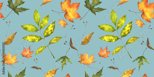 Seamless pattern of fall coloured bright hand-painted leaves on blue background.