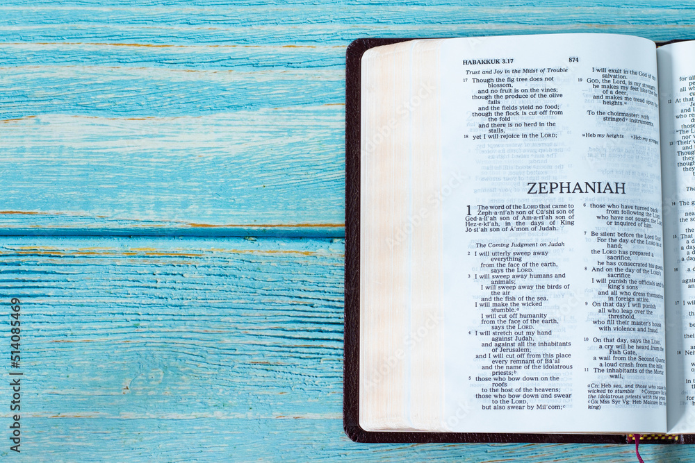 Zephaniah open Holy Bible Book on a rustic wooden background with copy ...