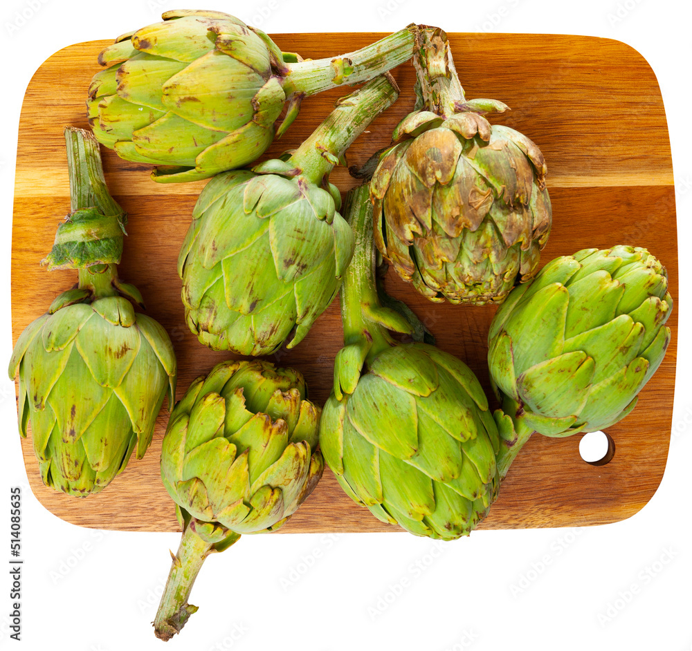 Fototapeta premium Fresh ripe artichokes lying on a cutting board. Ingredients for cooking. Isolated over white background