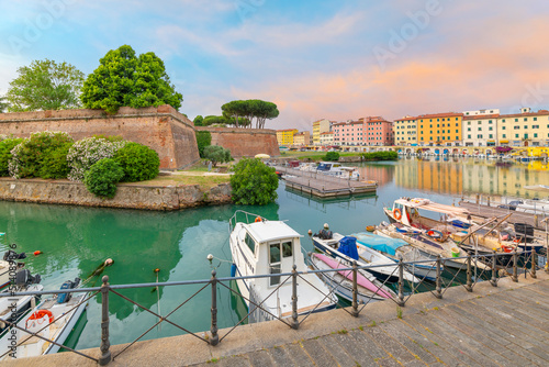 Fototapeta Boats line the crowded canals next to the New Fortress at the seafront Tuscan city of Livorno, Italy