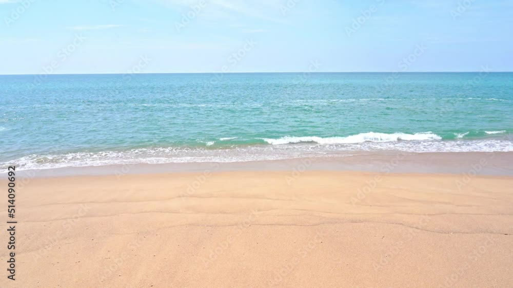 Tropical sand beach against the blue sky with waves splashing Tropical sand beach against the blue sky with waves splashing