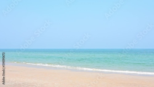 Waves crashing gently on a quiet sandy beach in Maui, Hawaii photo