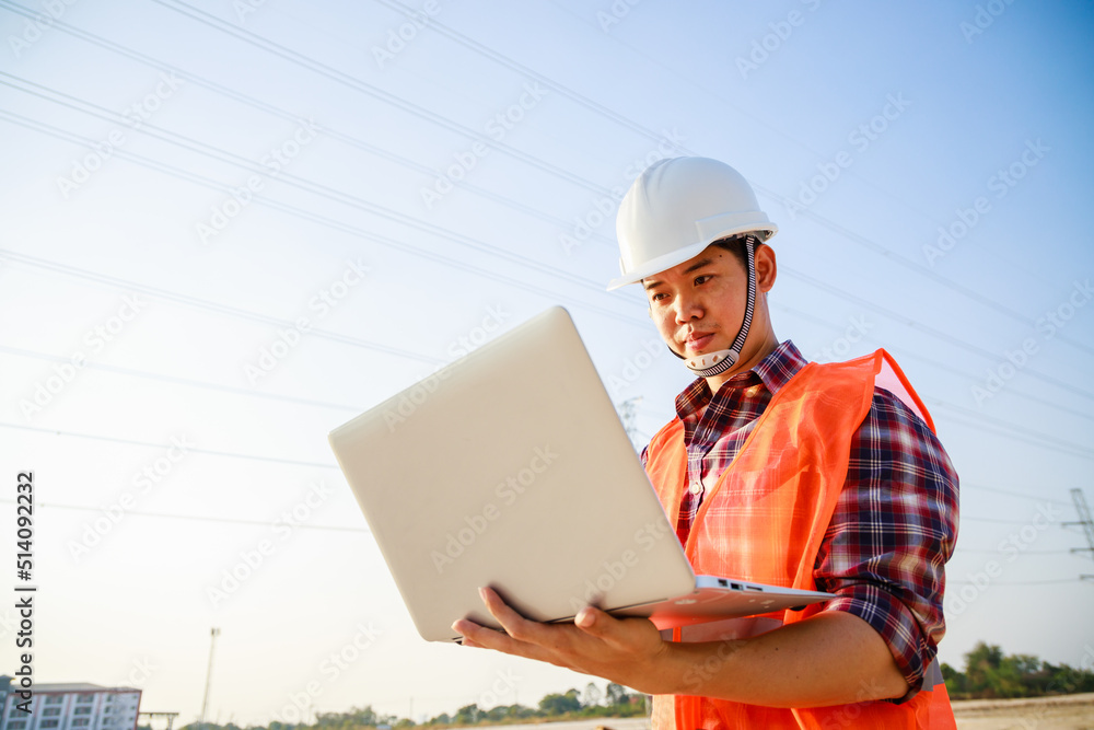 Asian engineer manager using computer laptop at construction site project on workplace