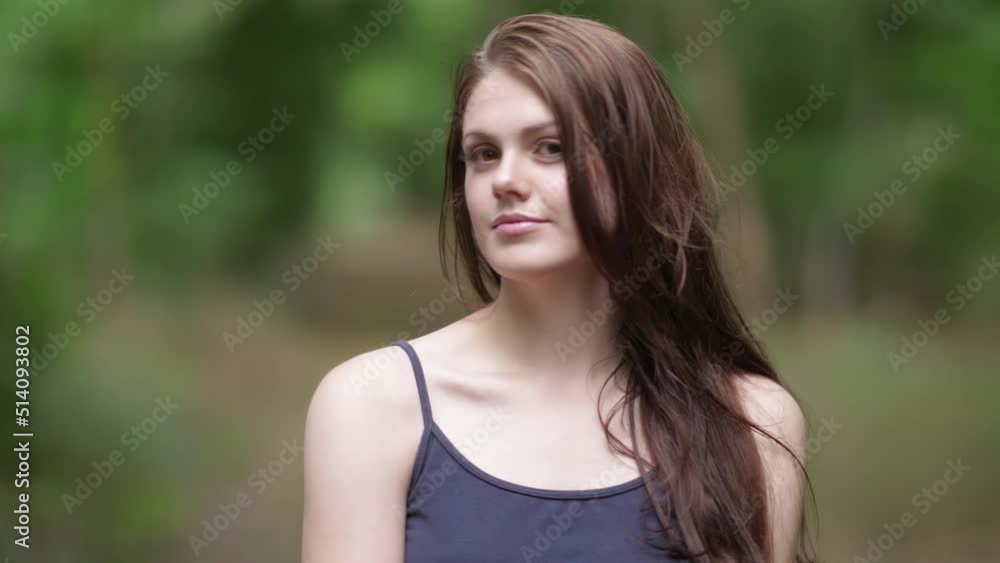 Portrait of young long-haired woman fondly posing in green nature Portrait of young long-haired woman fondly posing in green nature