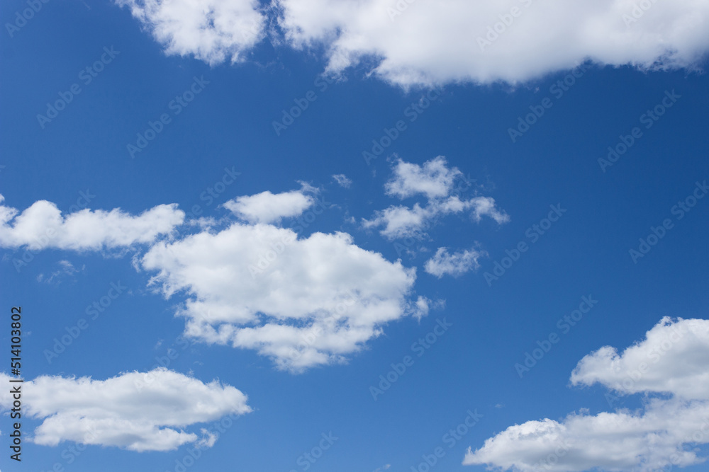 White clouds in a blue sky on a sunny summer day. Background, blank White clouds in a blue sky on a sunny summer day. Background, blank