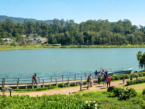 Nuwara Eliya, Sri Lanka - March 10, 2022: People walk in Gregory Park along the lake on a sunny day photo