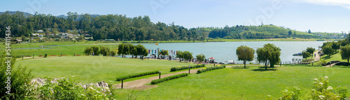 Nuwara Eliya, Sri Lanka - March 10, 2022: Panoramic view of the green landscape in Gregory Park and the lake on a sunny day photo