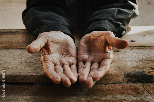 Tableau sur toile Close up of male wrinkled hands, old man is wearing on the wood