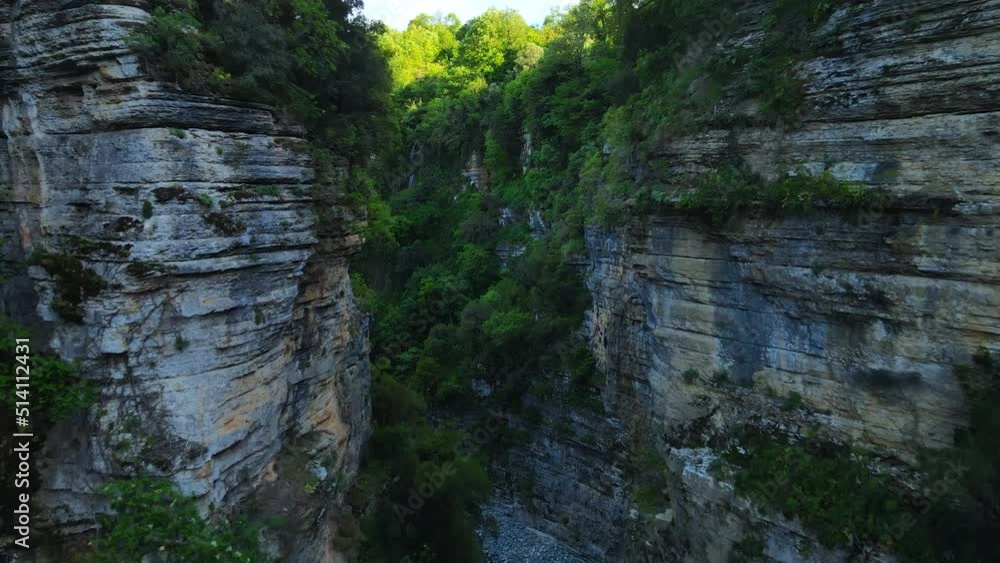 Aerial zoom-in shot of a metal bridge in the Osum canyon in Albania. High rocky cliffs and natural rock formation of the Osum canyon (Kanionet e Osumit) with dense green foliage. 4K UHD Aerial zoom-in shot of a metal bridge in the Osum canyon in Albania. High rocky cliffs and natural rock formation of the Osum canyon (Kanionet e Osumit) with dense green foliage. 4K UHD