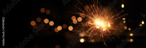 Happy New Year background with glowing sparklers. © Cosmina