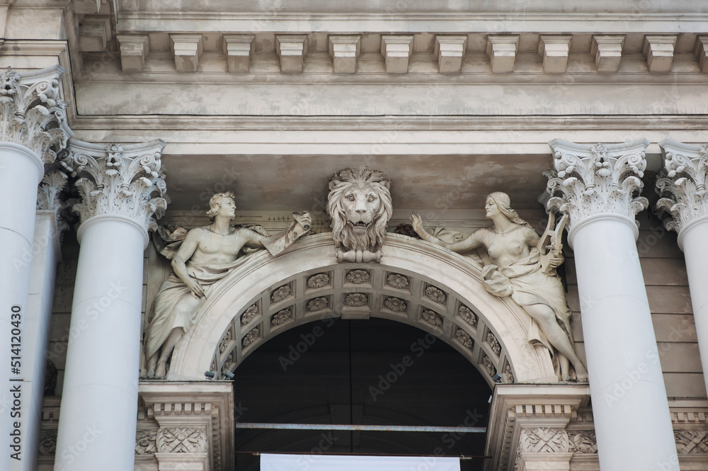Fototapeta premium Sculptures of two muses with lyre and paper with pen as allegories of the arts. The head of a lion on the facade of the Opera and Ballet Theater in Lviv, Ukraine. Neo-Renaissance in architecture.