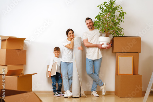 Portrait of happy family with cardboard boxes in new house at moving day © fotofabrika