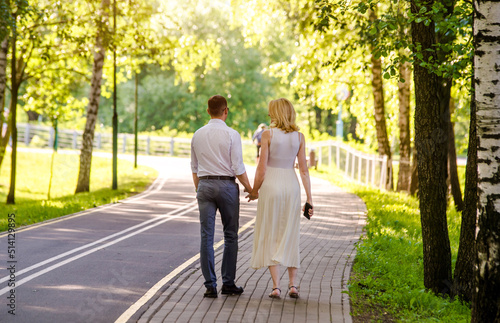 A guy and a girl walk along the path in the city Park
