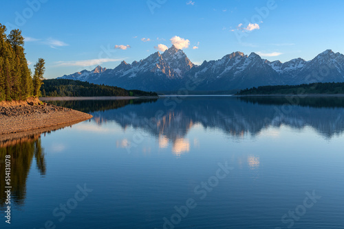 Tetons reflecting on a lake and wilderness.