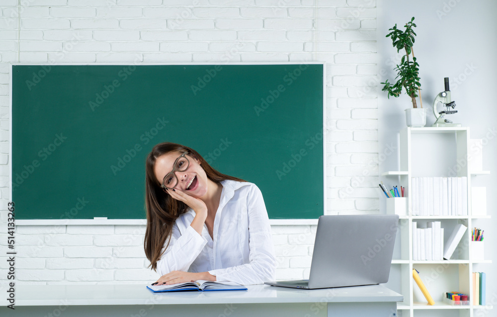Portrait of smiling young college student studying with laptop computer in classroom. Online learning at school, distance education. Portrait of smiling young college student studying with laptop computer in classroom. Online learning at school, distance education.
