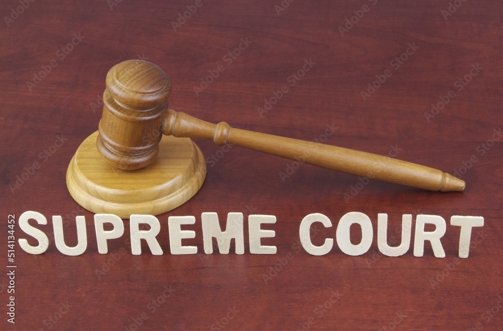 Supreme court decision concept. Words supreme court and wooden judge gavel.