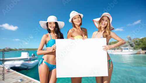 Obraz na płótnie travel, tourism and summer vacation concept - happy women in bikinis holding bla