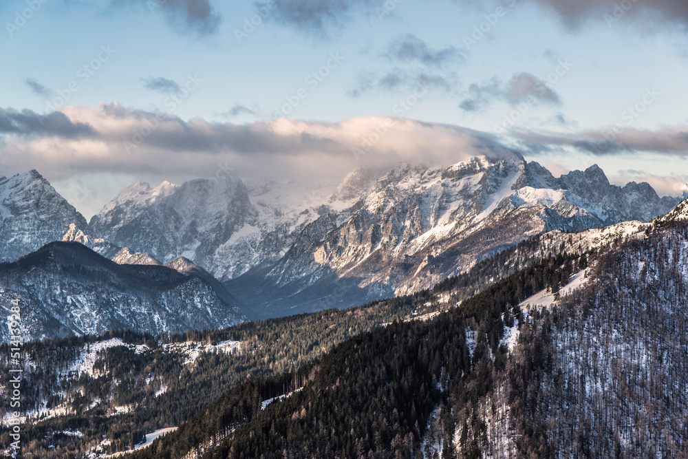 Fototapeta premium Winter peaks with fresh snow and clouds above it. 