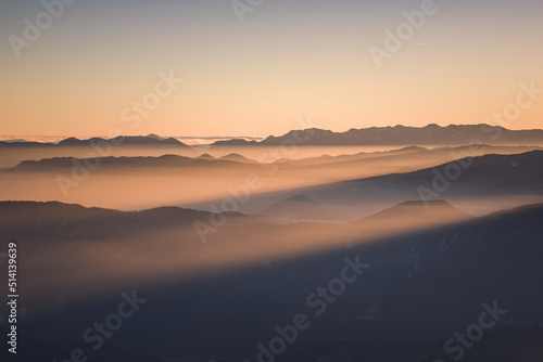 Foggy sunset in the mountains. Mist is covering the hills in the early evening.