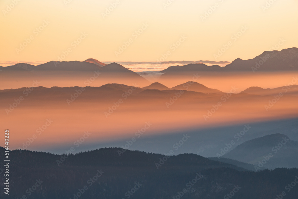 Foggy sunset in the mountains. Mist is covering the hills in the early evening.
