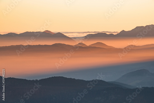 Fototapeta Naklejka Na Ścianę i Meble -  Foggy sunset in the mountains. Mist is covering the hills in the early evening.