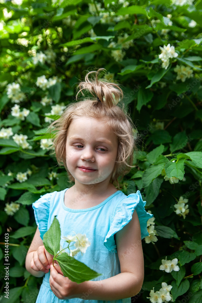 Cute blonde baby girl near jasmine bush Cute blonde baby girl near jasmine bush