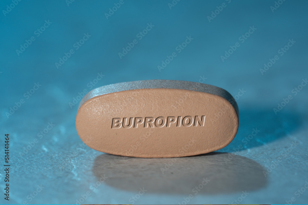 Bupropion drug Pill Medication ob blue background Bupropion drug Pill Medication ob blue background