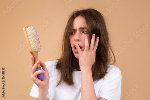 Hair loss problem treatment. Portrait of woman with a comb and problem hair.