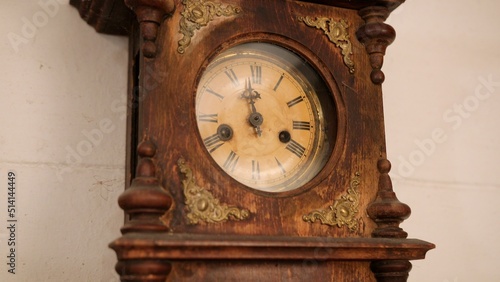 Broken antique mechanical wall clock that once showed the hour in room. Time measurement. Antique entourage. Close up