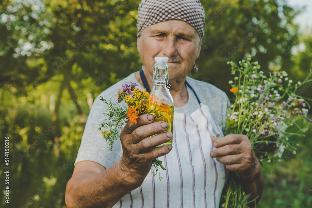 Fototapeta premium Old woman makes herbal tincture. Selective focus.