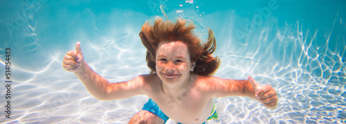 Child swim and dive underwater in the swimming pool.