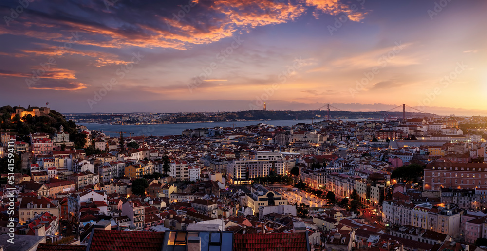 Panoramic view of the illuminated cityscape of Lisbon, Portugal, with Sao Jorge Castle and the Alfama district until the Tagus river just after sunset