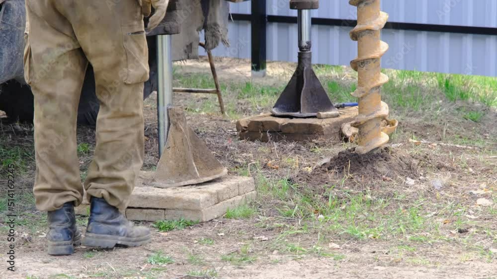 Team of workers with drilling rig on car are drilling artesian well for