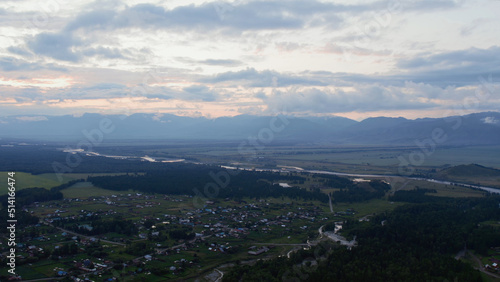 Aerial view of valley and country houses under blue sky in sunset time