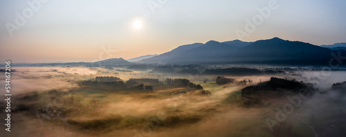 Sunset Panorama with drone at the Bavarian Alps. Mist and fog at the ground