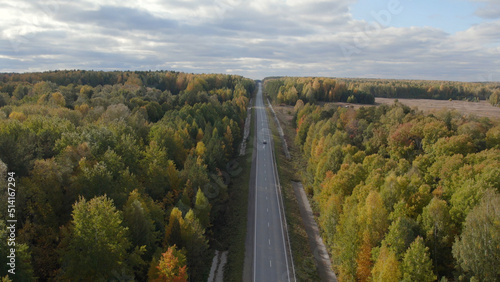 Asphalt road with traffic cars between forest in Ural