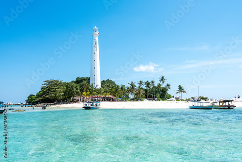 Lengkuas Island, Belitung, Indonesia. Beautiful small island with lighthouse surrounded by boats coming in and beuatiful clean blue sea water photo