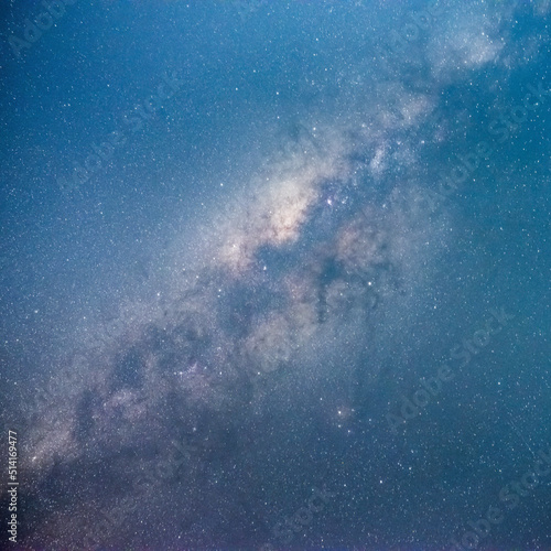 Square format milky way in with blueish tone with stars and space dust in the universe