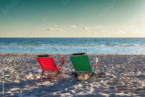 Sunset beach. Lounge beach chairs in white sand beach with accessory in Naples Beach, Florida, USA. Vintage processed. 