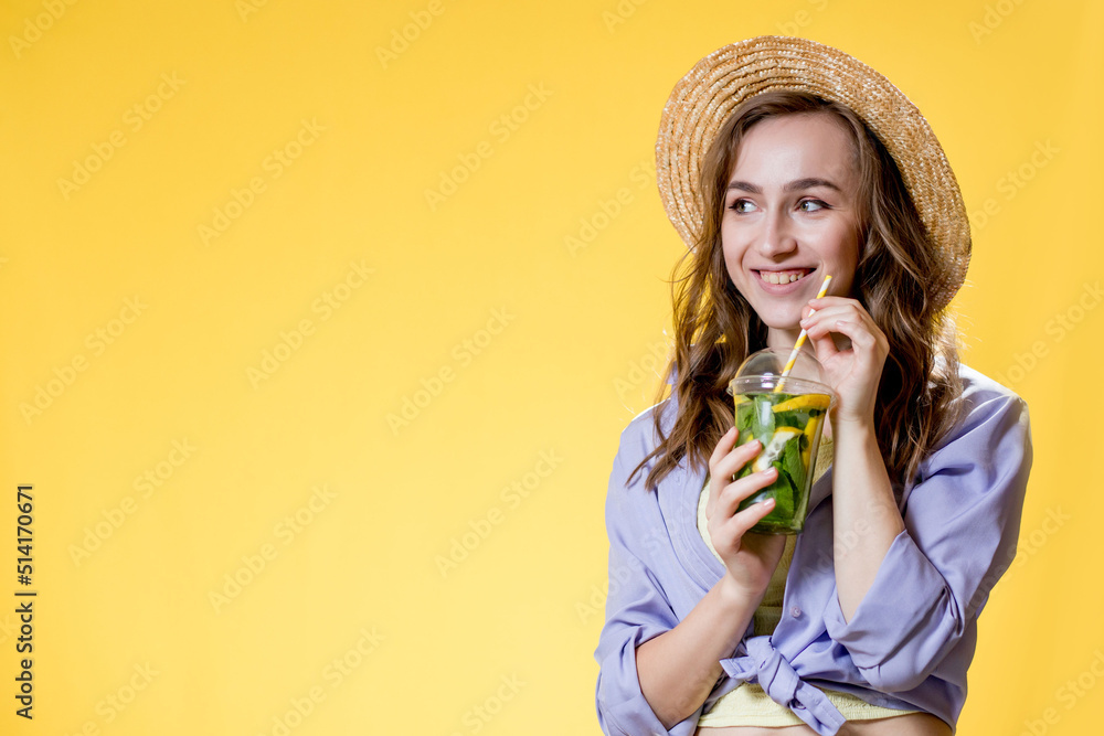 Woman in summer outfit wearing white trendy sunglasses and enjoying while drinking a Mojito cocktail. Posing on the yellow background Woman in summer outfit wearing white trendy sunglasses and enjoying while drinking a Mojito cocktail. Posing on the yellow background