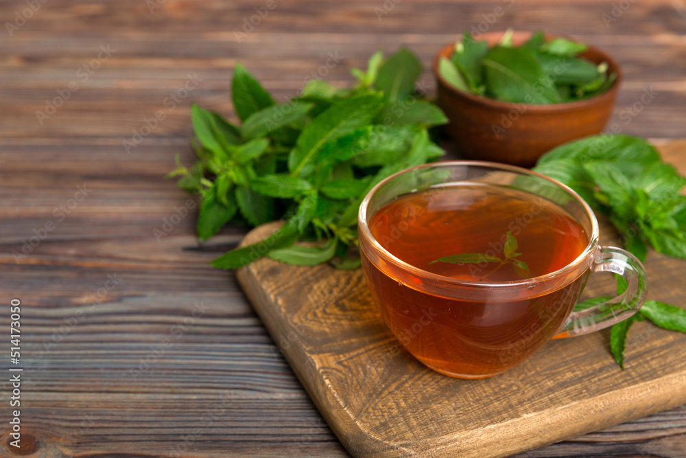 Cup of mint tea on table background. Green tea with fresh mint top view with copy space Cup of mint tea on table background. Green tea with fresh mint top view with copy space